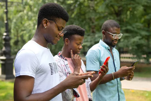 Jóvenes Africanos Con Teléfonos Móviles Parque Verano —  Fotos de Stock