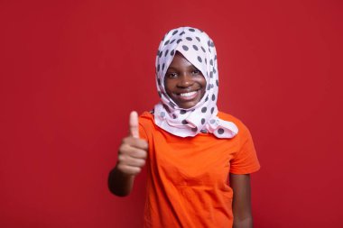 Geleneksel Arap türbanlı, el hareketleriyle neşeli Afrikalı kadın.