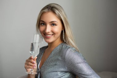 Bir bardak şampanyası olan güzel, çekici bir kadın.