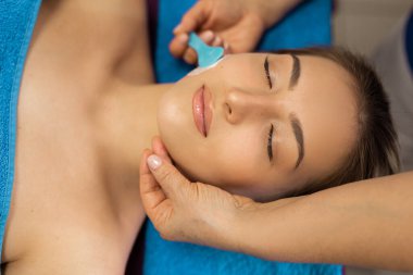 Bir güzellik uzmanıyla randevuda olan güzel genç bir kadın.