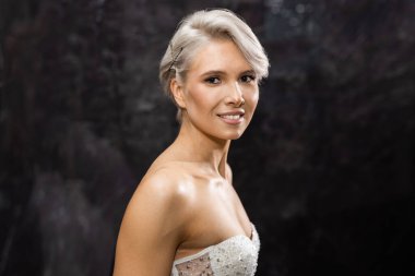 Makyajlı ve kısa saçlı beyaz bir kadın.