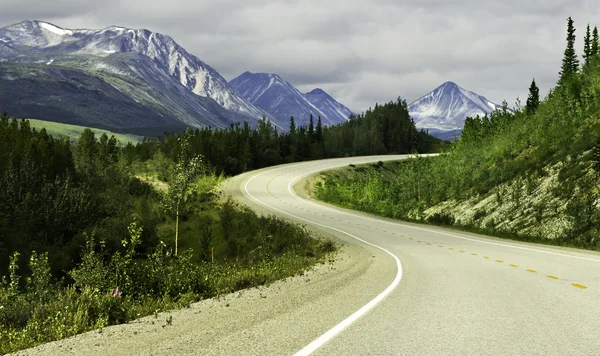 Camino de asfalto en las altas montañas de Alaska Fotos de stock libres de derechos