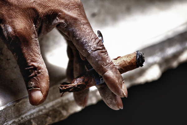 Hand keeping smoldering cigar