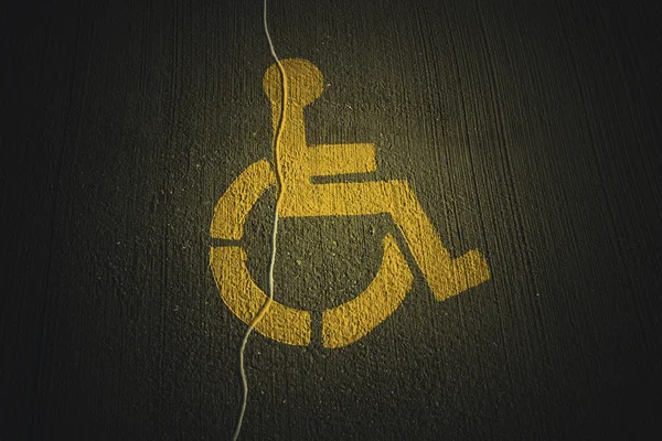 Behinderte Ikone auf kaputtem Asphalt — Stockfoto