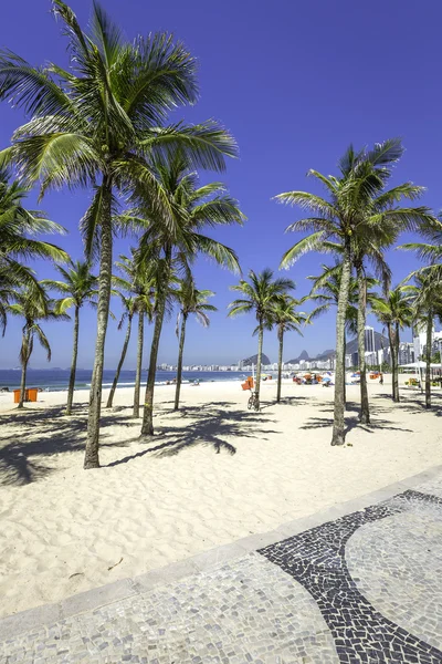 Praia de Copacabana com palmeiras e mosaico calçadão no Rio de Janeiro — Fotografia de Stock