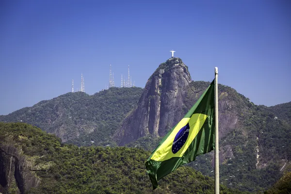 Krista Spasitele proti brazilská vlajka v rio de janeiro, Brazílie — Stock fotografie