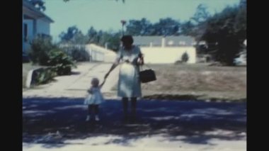 Dallas, ABD Haziran 1958: Gururlu bir büyükanne torunuyla birlikte 50 'li yaşlarda sonbaharda kaldırımdan aşağı yürür.