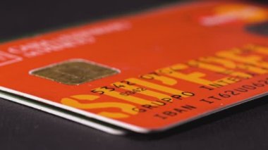 Adamın biri banka kartlarını yığının içine koyuyor. Kullanılmış kredi kartı desteleri masanın yakın çekim görüntülerine seriliyor..