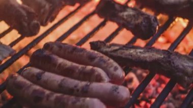 Kızarmış etli biftek, baharat ve otlarla birlikte, yanan kömürlerin içinde, bbq ızgarası, alevler ve duman. Izgara çizgili sulu et piknik kutlaması için hazır. Barbekü ızgarası