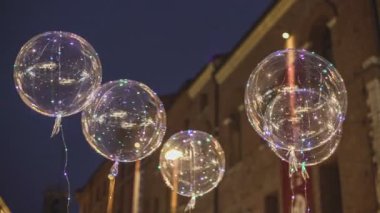 Renkli LED ışıkları olan balonlar eski turistik şehir merkezinin gece caddesinde satılıyor..