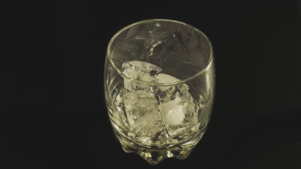 In Zeitlupe Whiskey mit Eiswürfeln ins Glas gießen