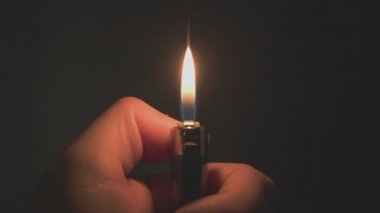 Yüksek hızlı kamerayla yavaş çekimde, arka planda çakmak olan yanan ateş.