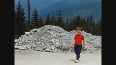 DOLOMITES, İTALYA MAYIS 1969: Çocuk 60 'larda dağ yolunda koşuyor
