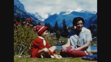 DOLOMITES, İTALYA MAYIS 1969: 60 'larda annem çocuklarla bahçede oynuyor