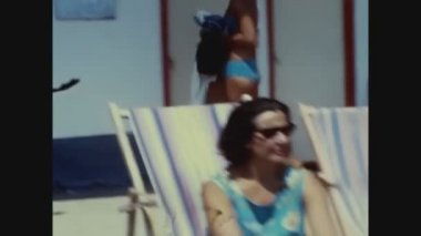 SANREMO, İTALYA 1967: 60 'larda deniz kenarında güneşlenen kadın