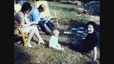 SANREMO, İTALYA MAYIS 1962: 60 'larda bebeğiyle bahçede bir aile