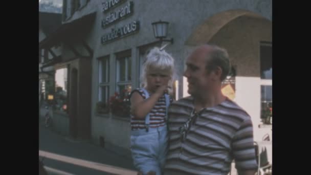 1968年6月26日 意大利Cogne 六十年代 祖父抱着孙女走在大街上 — 图库视频影像