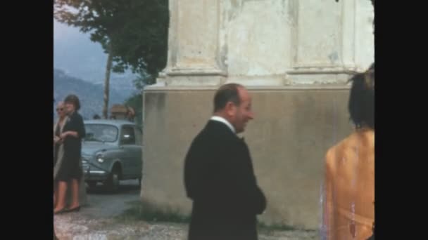 1969年 昭和44年 5月イタリア コモ教会外で待つ 人々は外を歩き 話します 男ポーズ花嫁のために肖像画 — ストック動画