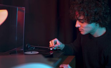 Genç adamın portresi bir plak plağı dinliyor.