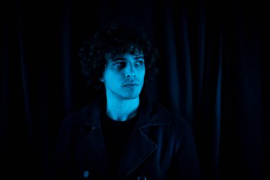 Karanlık arka planda melankolik bir adamın portresi.