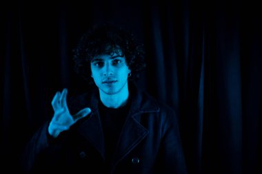 Yumuşak mavi ışıklı bir tiyatrocunun portresi.