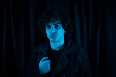 Karanlık arka planda melankolik bir adam. Yüzü koyu gölgede