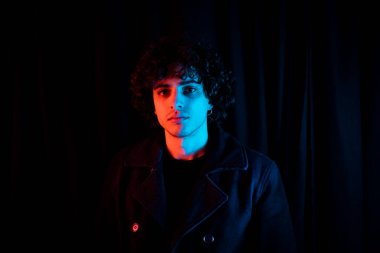 Karanlık arka planda melankolik bir adam. Yüzü koyu gölgede