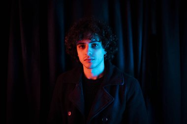 Karanlık arka planda melankolik bir adam. Yüzü koyu gölgede