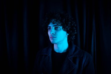 Karanlık arka planda melankolik bir adam. Yüzü koyu gölgede