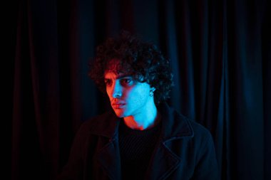 Karanlık arka planda melankolik bir adam. Yüzü koyu gölgede