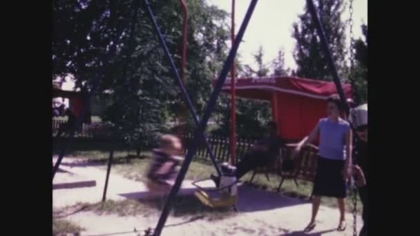 ミラノ イタリア6月1967 子供たちはスイングと60の公園での乗り物で遊ぶ — ストック動画