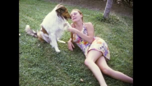 スペインのセチェディージャ1976年5月 牧草地の少女が70代のラフ コリー犬を抱きしめる — ストック動画