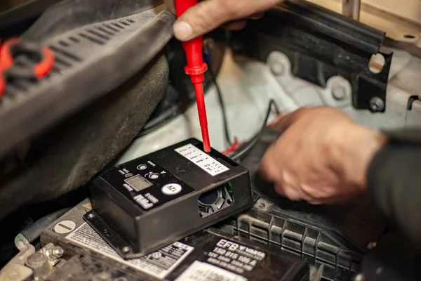 MILAN, ITALY 24 Nisan 2022: Tamircinin elleri araba motorundaki hidrojen kontrol ünitesini ayarlar