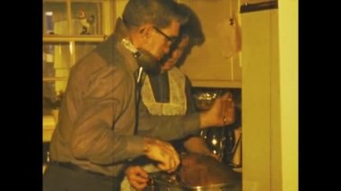Lynn, United States may 1960: Man prepares turkey for thanksgiving day in the kitchen in 60s