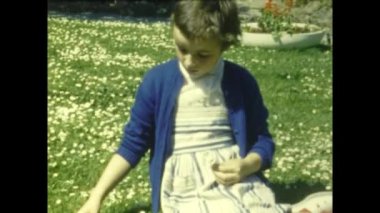 Grimaud, Fransa Haziran 1958: Çimlerin üzerinde oturan küçük kız 50 'li yıllarda çiçek topluyor