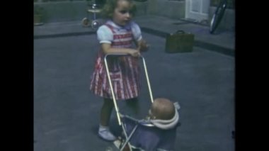Paris, Fransa Haziran 1953: Küçük kız 50 'li yıllarda oyuncak bebek ve bebek arabasıyla oynuyor