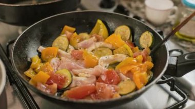 Tencere kapağında sebzeli tavuk pişiyor. Metal tavada sebzeli haşlanmış tavuk..