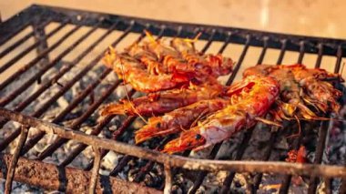 Izgara karides (Dev tatlı su karidesi) ve mangal kömürü. Izgarada ızgara karides ve mangal. Yağlı tavada kızartılan karideslerin yakın çekimi.