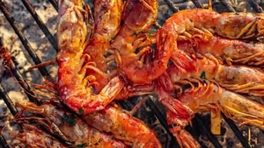 Izgara karides (Dev tatlı su karidesi) ve mangal kömürü. Izgarada ızgara karides ve mangal. Yağlı tavada kızartılan karideslerin yakın çekimi.
