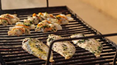 Pour seasoning over the grill fish. Drizzling oil on a grilled seafood.