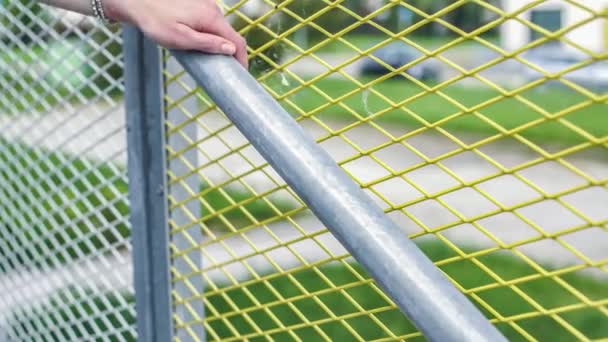 Girl Comes Downstairs Holds Handrail Net Fence Wearing Bracelet — Stockvideo