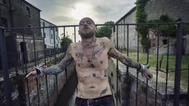 Man Tattooed Body Hands Tied Struggles Escape Mutters Ask Help — стоковое видео
