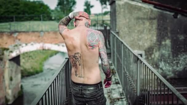 Exhausted Man Body Covered Tattoos Walks Narrow Bridge Spits — Vídeo de stock