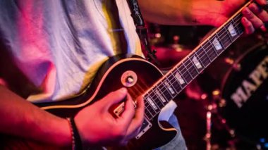 İnsan elleri gitar tellerinin ve akorların detaylarını bir performans sırasında çalar