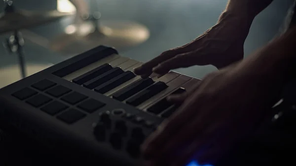 Man plays music using a sampler professional music equipment details of a piano