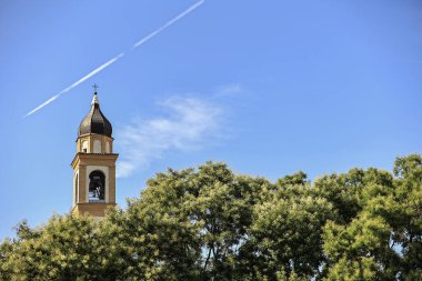 Church bell tower in the trees in Rovigo, Italy