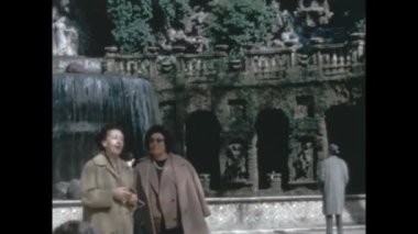 Assisi, Italy june 1960: People at ancient park with fountain in 60s
