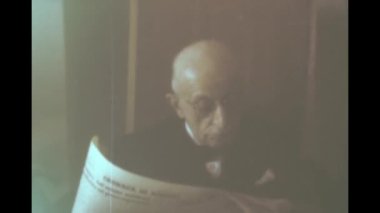Liguria, Italy june 1960: Old man reads newspaper scene in 60s