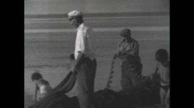 Catanzaro, Italy august 1962: Fishermen in vessel spread the net to catch fishes in 60s