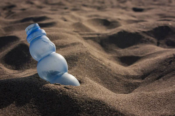 Pollution: a stranded Plastic waste on the sand of a beautiful Italian beach